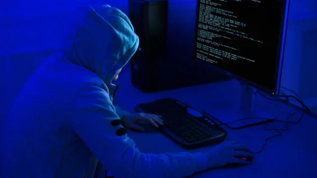 A hacker at a computer as government urges organisations to improve cyber security