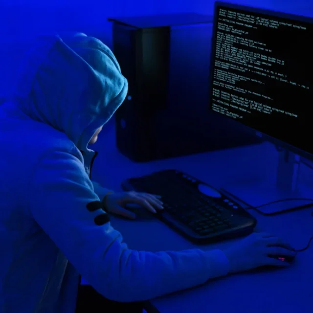 A hacker at a computer as government urges organisations to improve cyber security