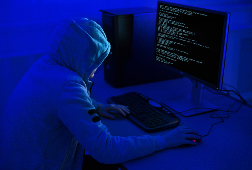 A hacker at a computer as government urges organisations to improve cyber security