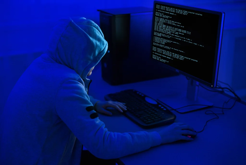 A hacker at a computer as government urges organisations to improve cyber security