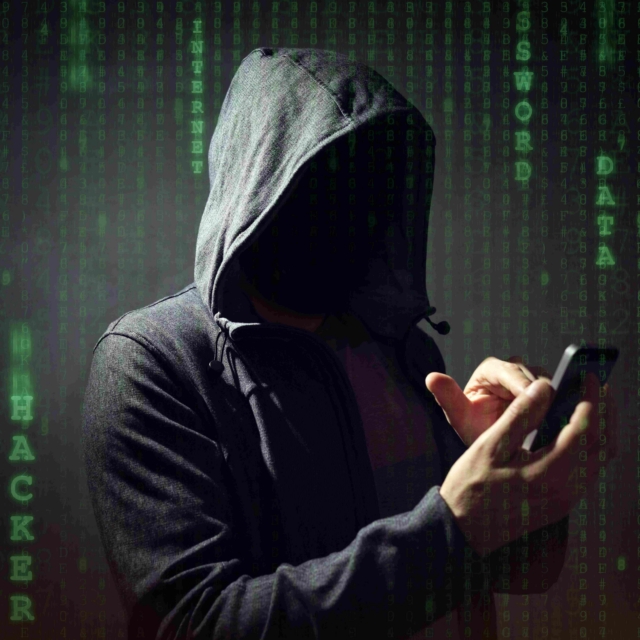 Computer hacker with mobile phone smartphone stealing data
