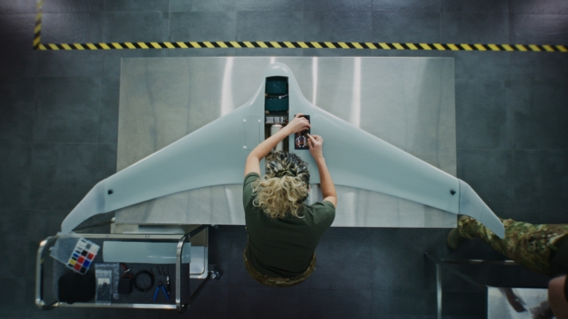 Woman in Camouflage Uniform Working installing batteries on Next Generation Drone.