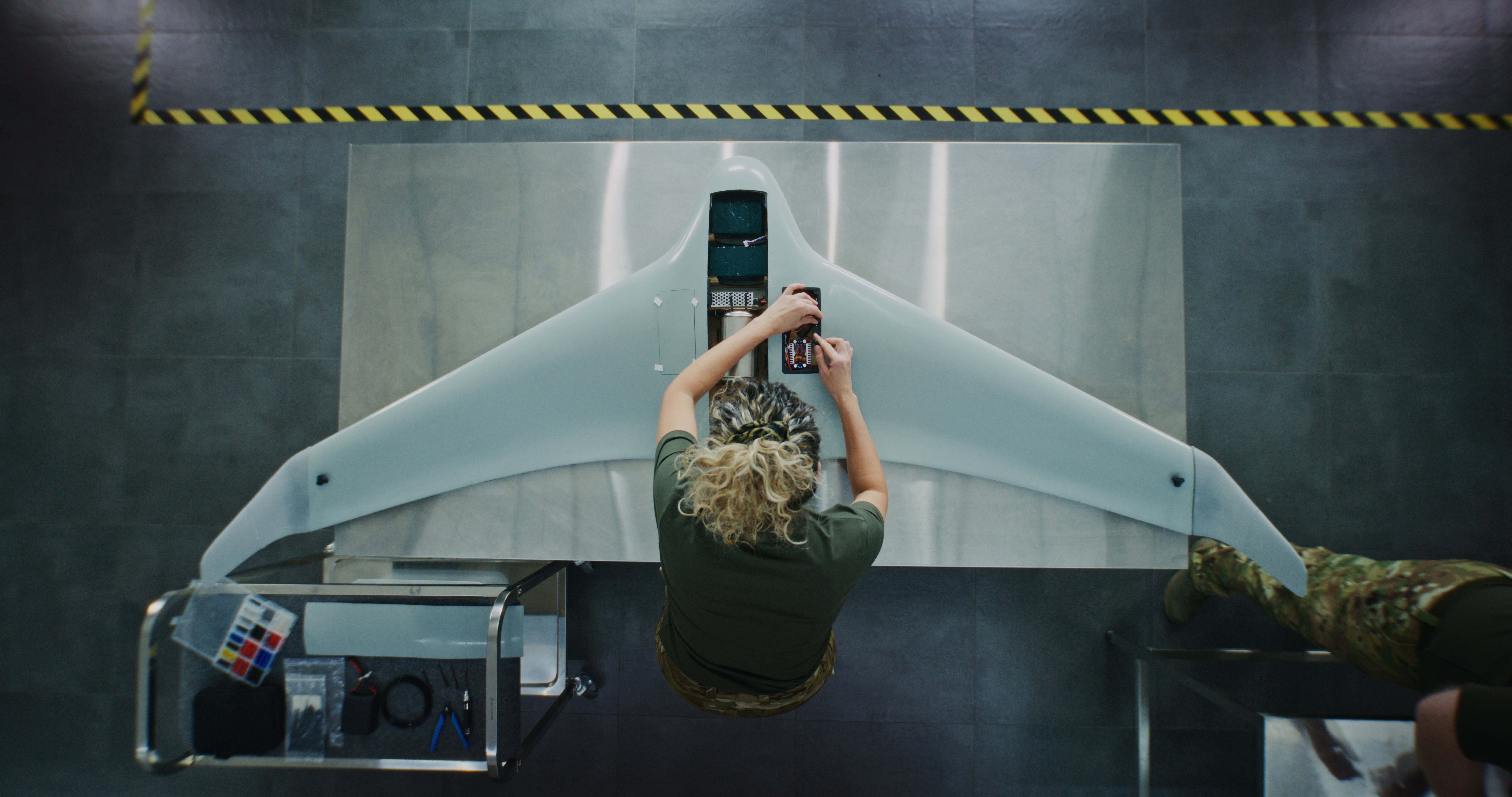 Woman in Camouflage Uniform Working installing batteries on Next Generation Drone.