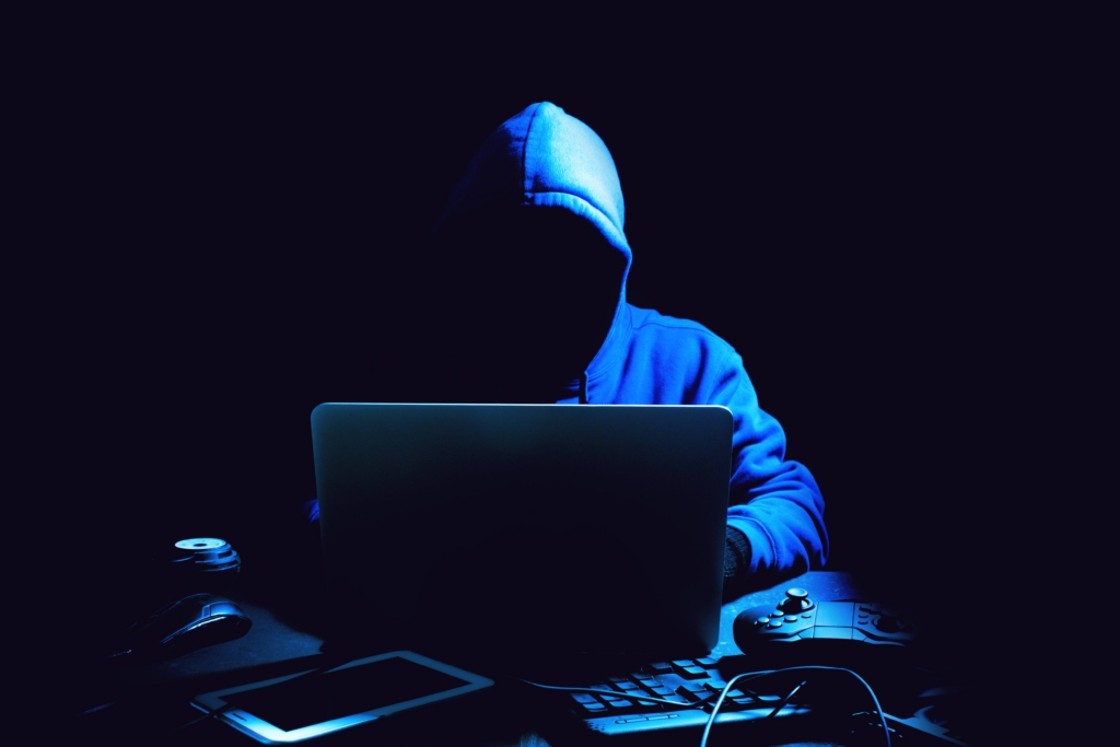 A computer hacker attempts to hack and compromise cyber security