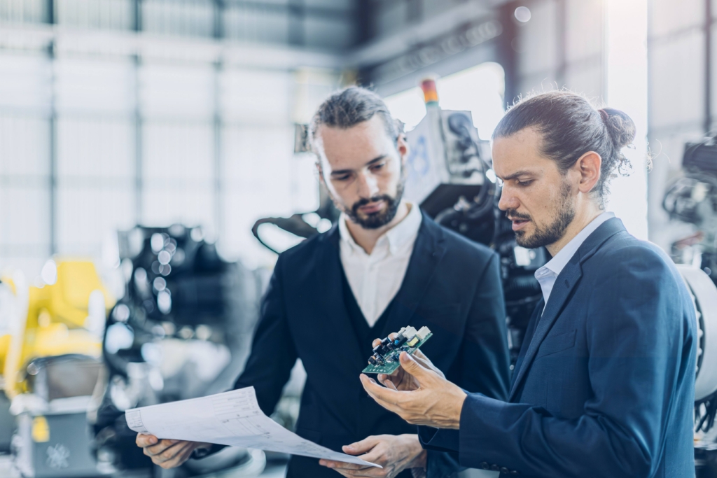 Engineer male advance robotic machine designer team talking with electronic component part supplier business consulting in heavy machinery industry concept.