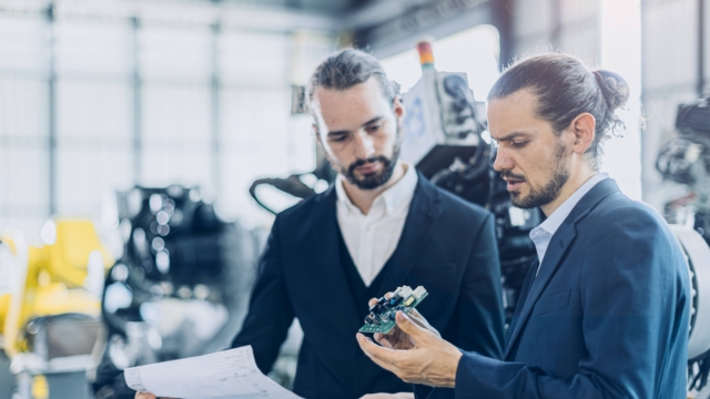 Engineer male advance robotic machine designer team talking with electronic component part supplier business consulting in heavy machinery industry concept.