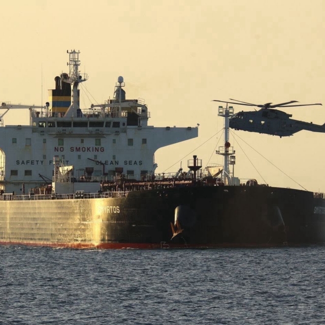 A Royal Navy-operated Merlin HM4 hovers over the deck of the sanctioned Cameroonian-flagged crude oil tanker and suspected Russian 'shadow fleet' vessel, Smyrtos, during a maritime interdiction mission to seize the vessel on 14 June 2026. Image: MOD Crown Copyright/Royal Navy
