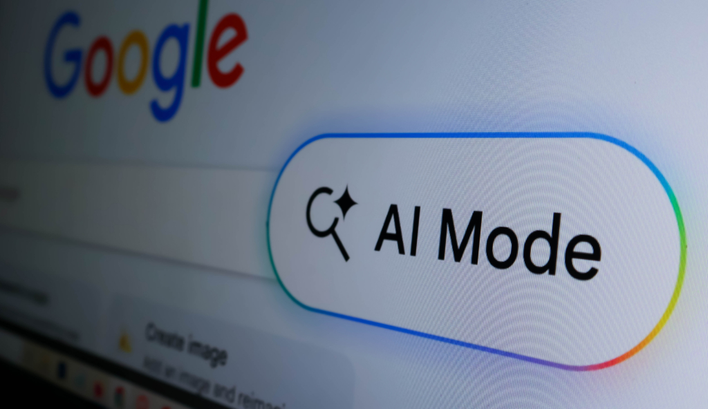 Closeup of a computer screen showing a google search bar with an ai mode button and a colorful glowing border