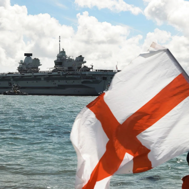 A youngster waves the Flag of St George as HMS Prince of Wales leaves Portsmouth in 2025