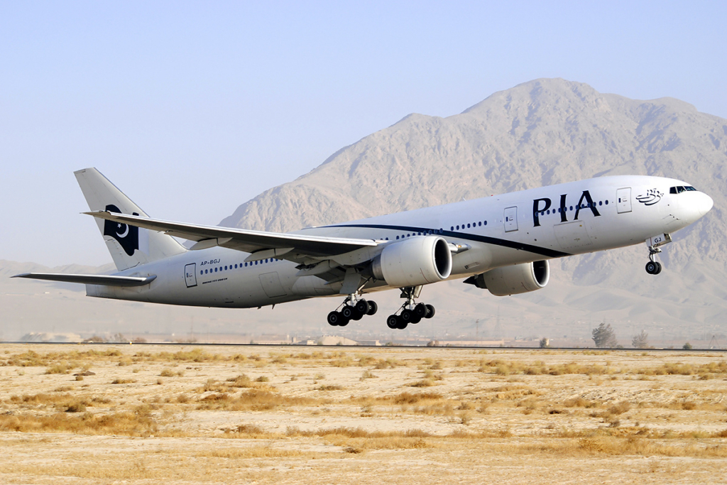Pakistan International Airlines Boeing 777 landing in front of a mountain.