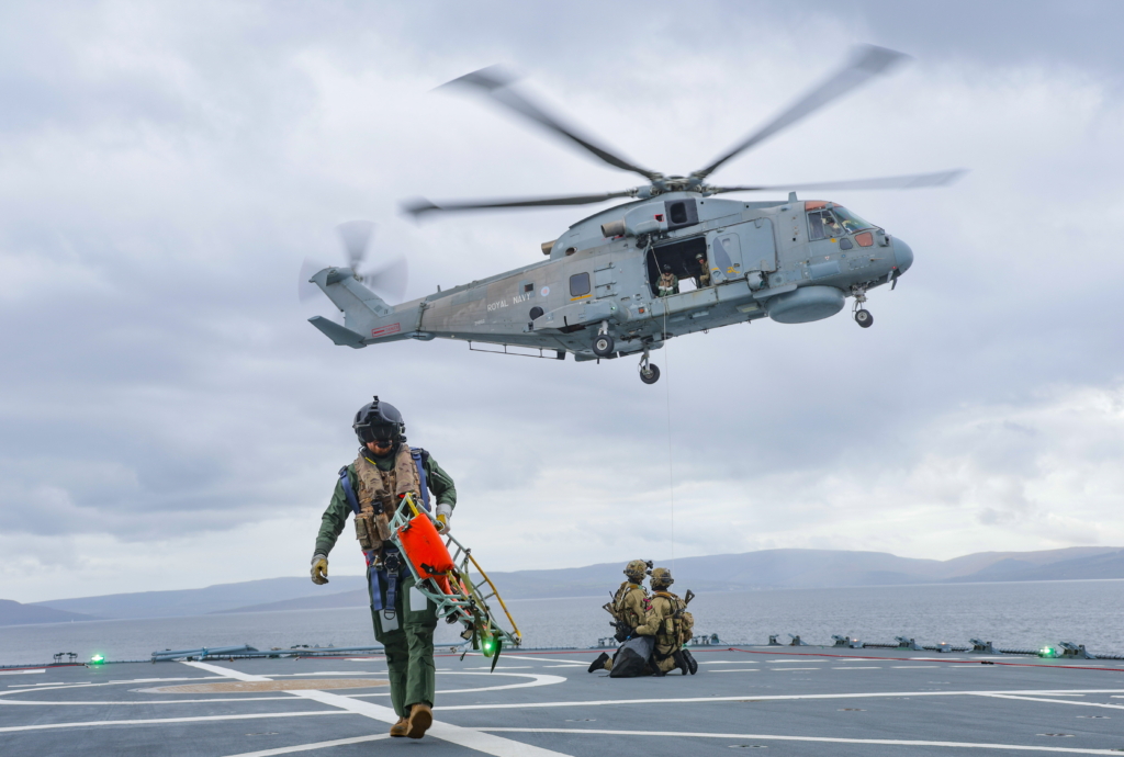Royal Marines from 42 Commando's K Company conduct fast-roping drills onto the German replenishment ship, FGS Berlin, from an 824 NAS-operated Merlin HM2 during Exercise Strike Warrior 2026. Image: MOD Crown Copyright/PH Gregory Sirc