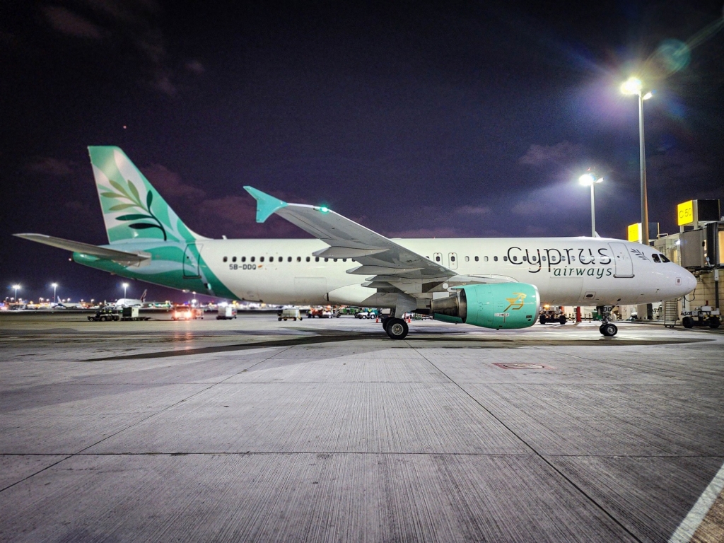 Cyprus Airways Airbus A320 aircraft at the gate at Dubai Airport in the night.